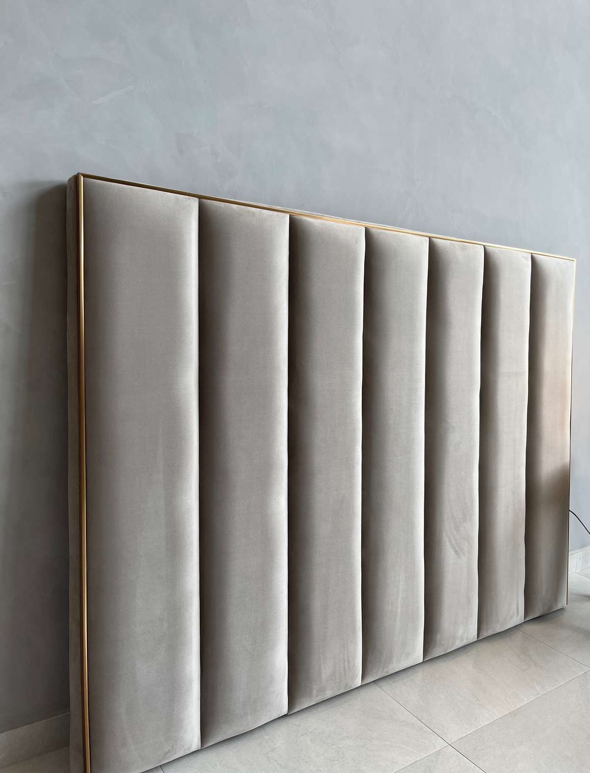 Wall-to-wall fluted headboard with gold trim, made to measure by Sheep & Sleep