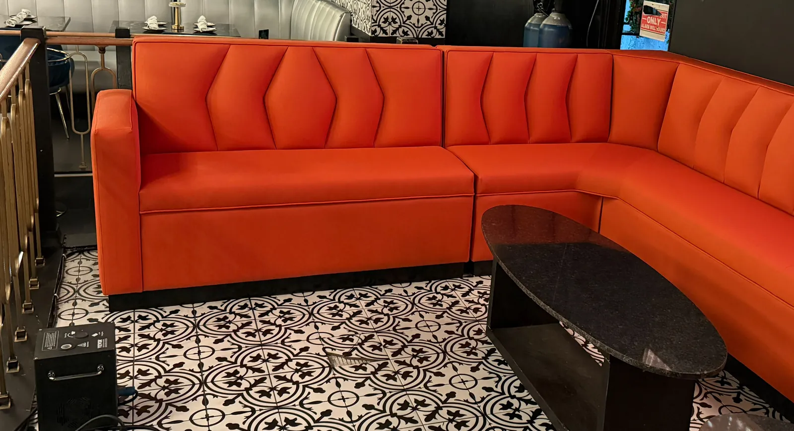 Orange vinyl corner booth with pointed channel backs around a lounge table in a gastro bar