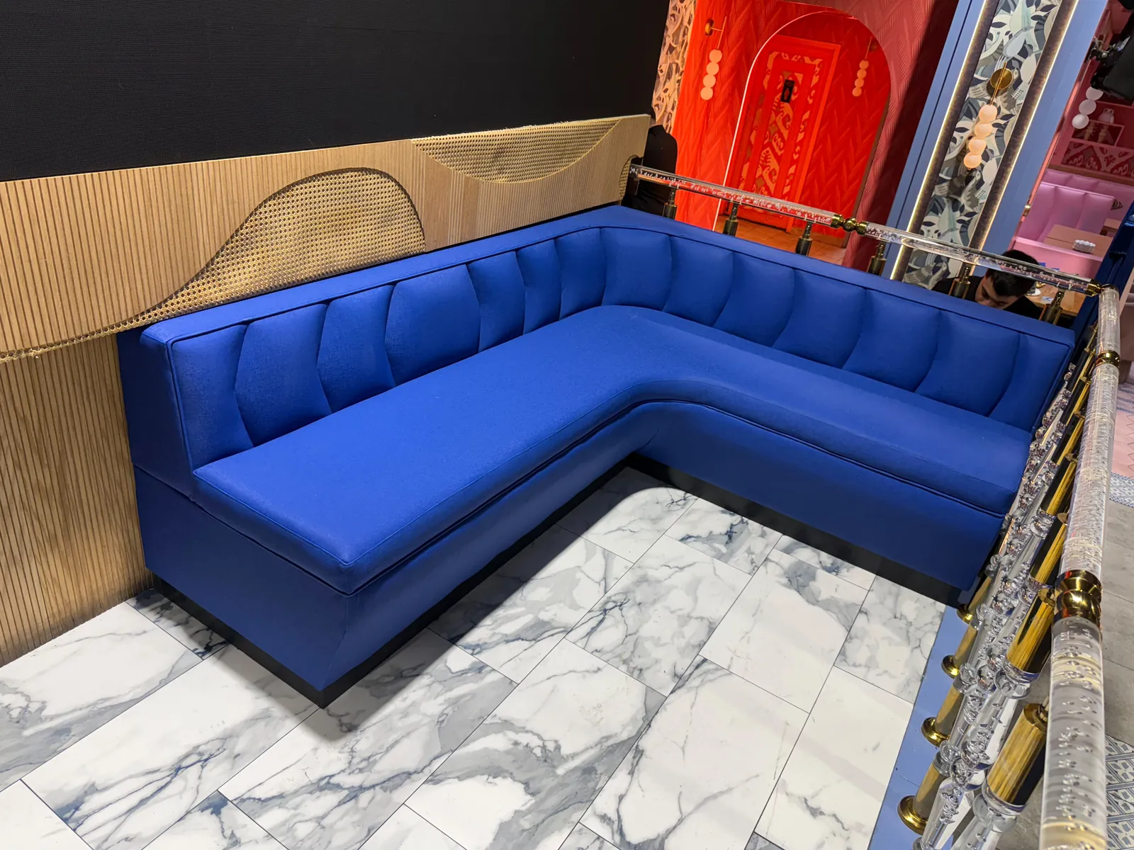 L-shaped royal blue vinyl booth with channel back over a marble floor in a restaurant