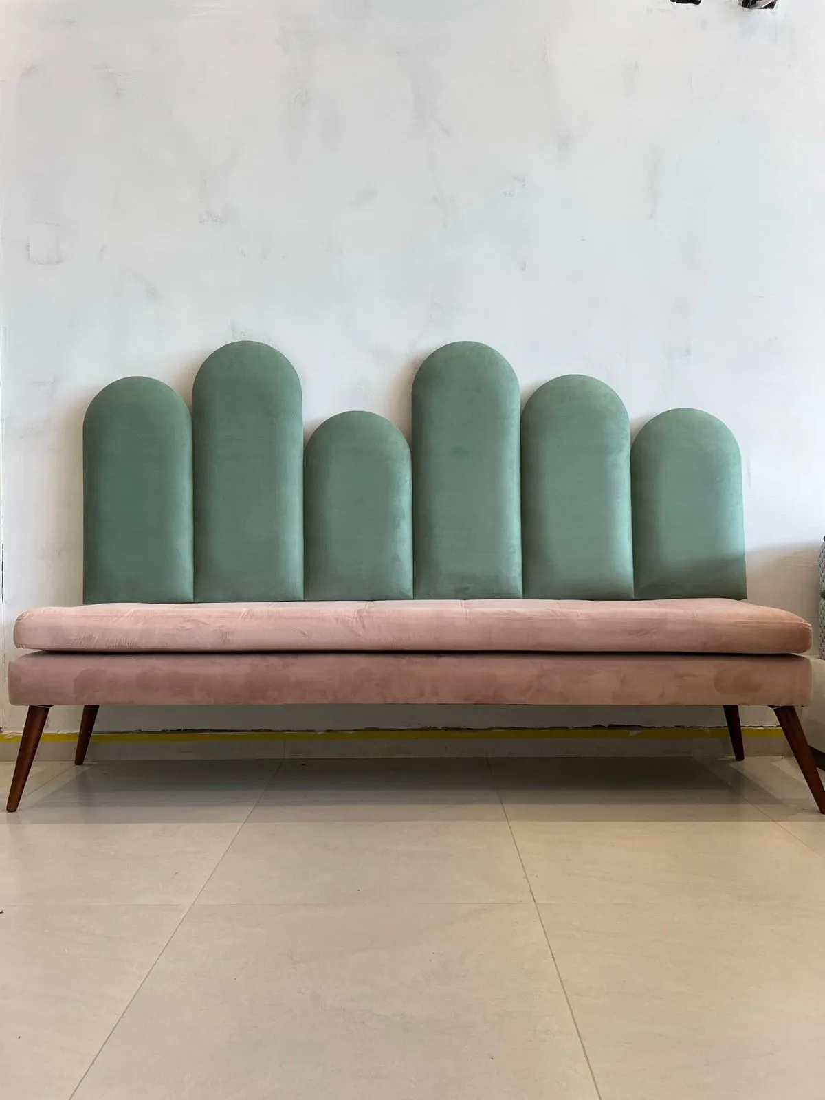 Painel de arcos em veludo verde-menta com banco rosé