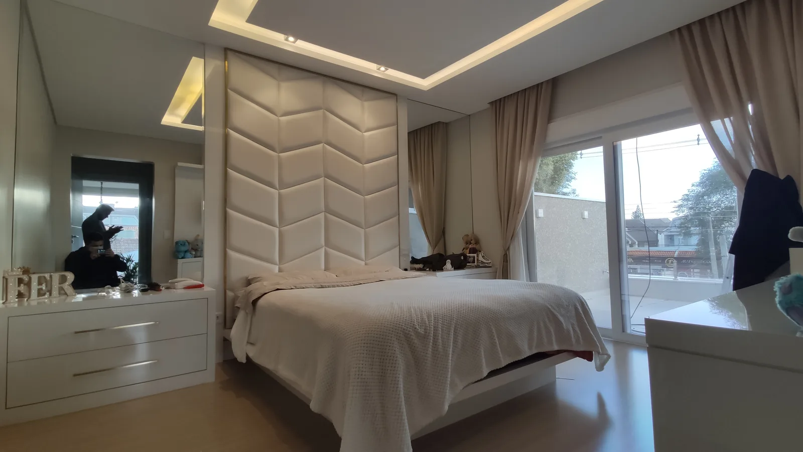 Painel estofado chevron branco do chão ao teto em quarto de luxo com sanca de LED