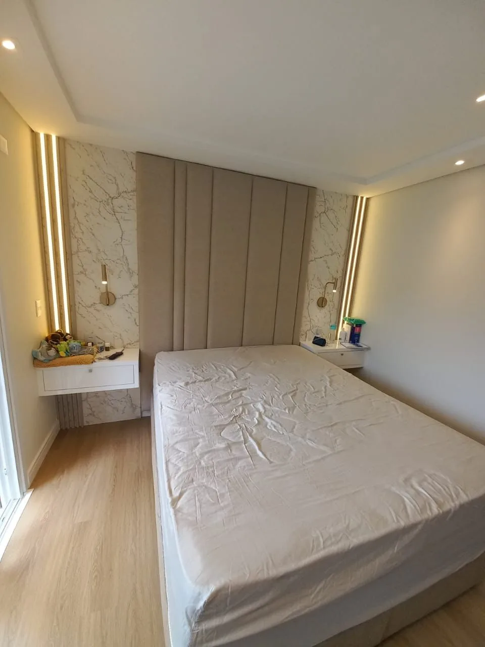 Painel de canaletas entre mármore e fitas de LED em quarto de cliente