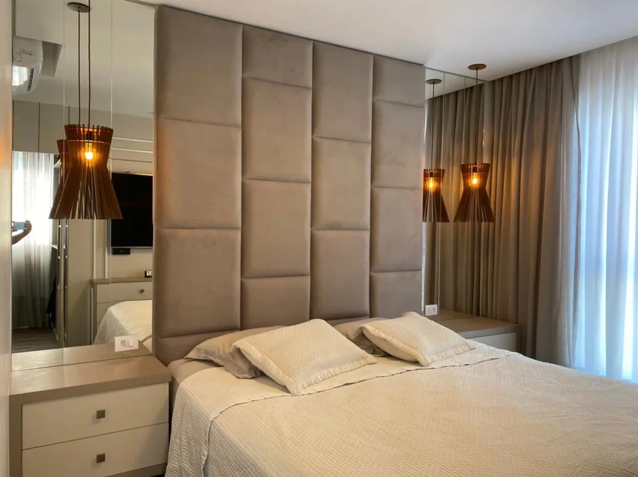 Painel estofado de veludo em placas instalado atrás da cama com arandelas