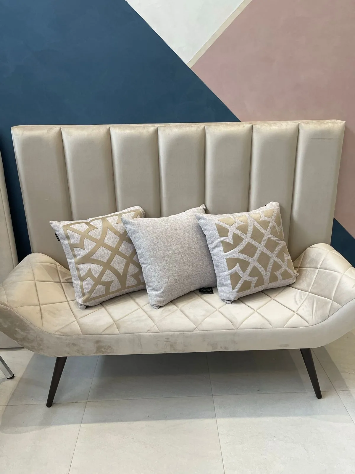 Recamier matelassê diamante com pés palito de madeira, com cabeceira de canaletas ao fundo