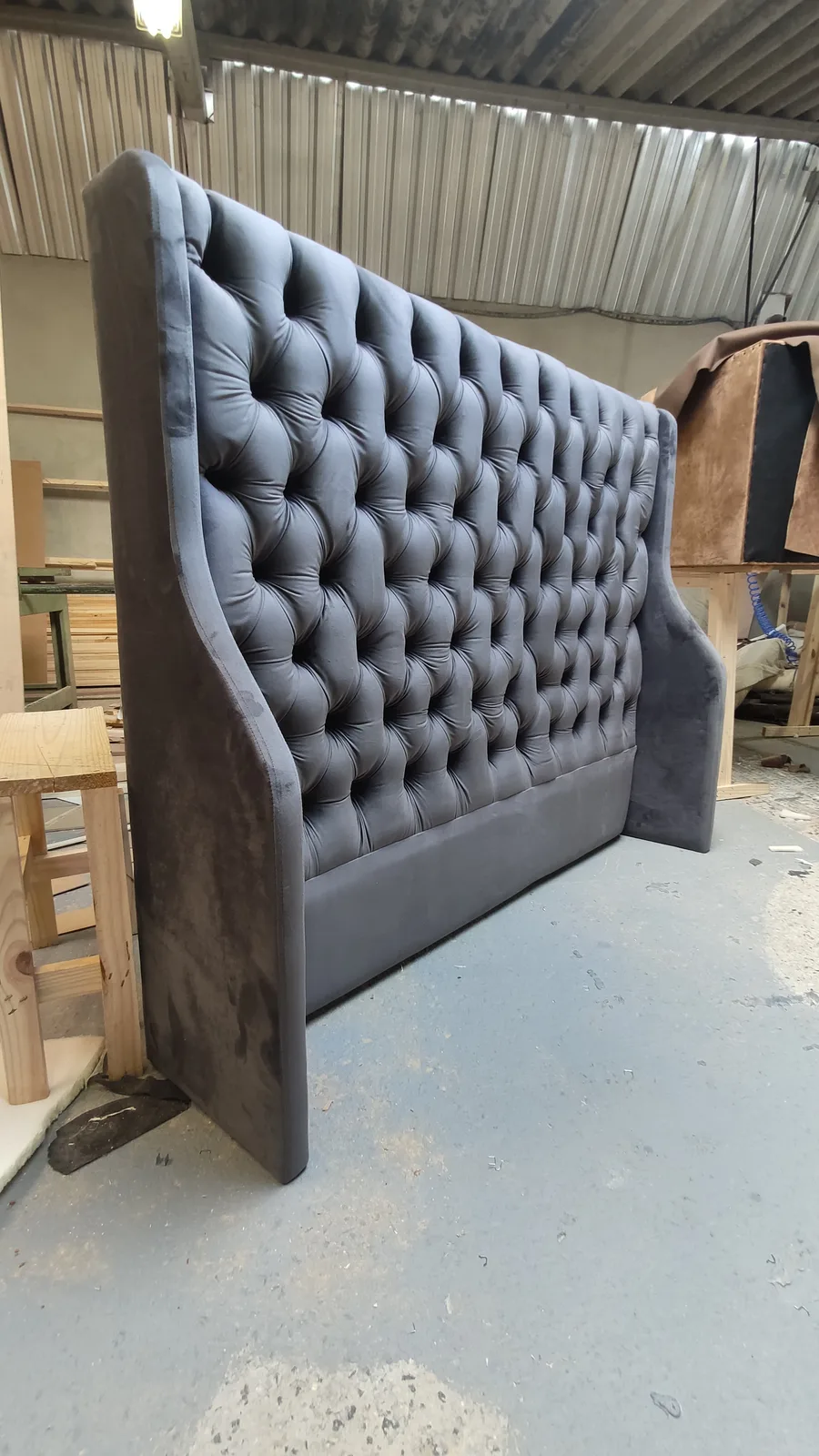 Dark gray tufted wingback headboard handcrafted at the workshop