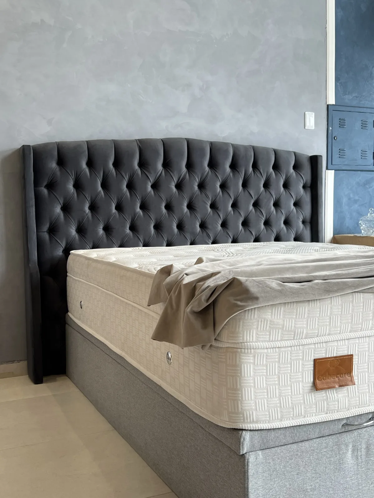 Graphite velvet tufted wingback headboard installed with mattress