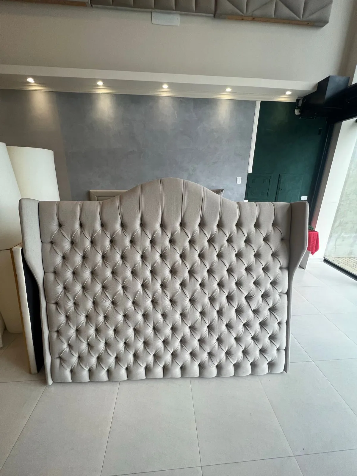 Cabeceira com abas capitonê fendi de topo arredondado no showroom