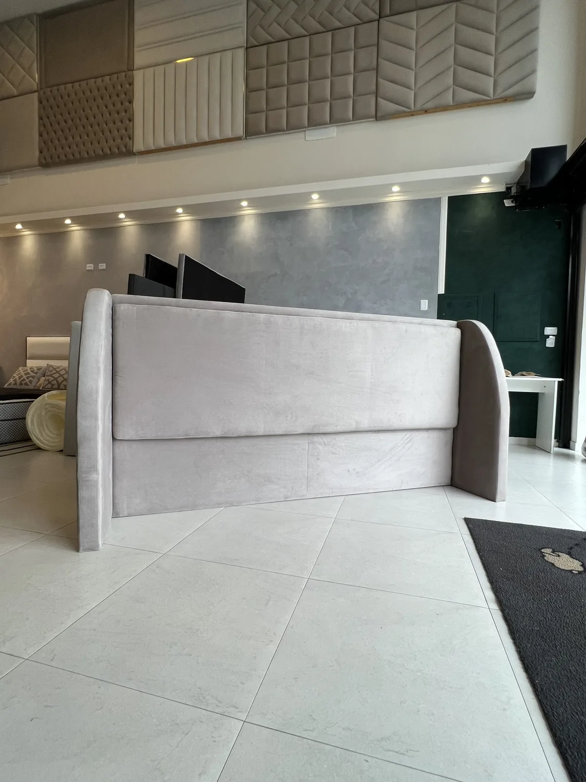 Modern wingback headboard with curved side wings in light velvet
