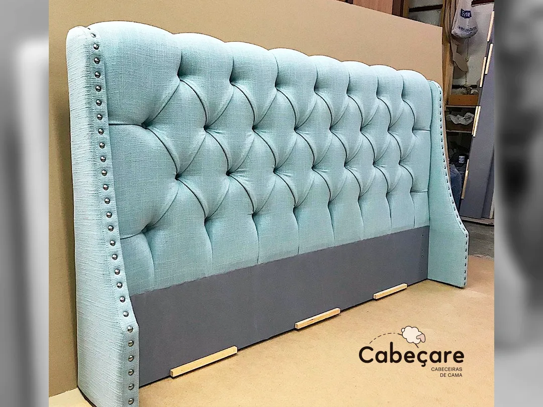 Light blue tufted wingback headboard with nailhead trim